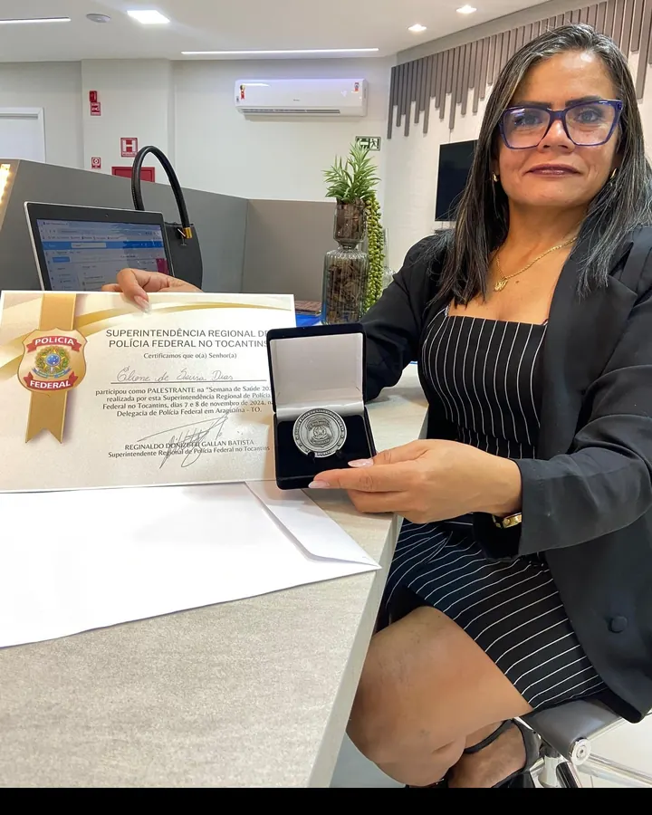 Eliene Dias segurando certificado e medalha da Polícia Federal